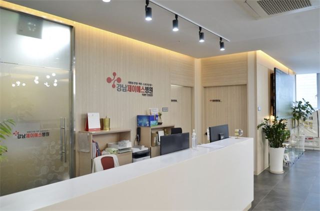 Reception desk with the hospital logo at Gangnam JS Hospital