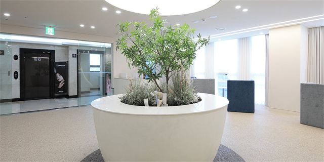 Lobby with a round planter and the elevator hall at Oaro Skin Clinic Cheongdam