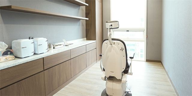 Treatment room with a treatment chair and a wall cabinet at Oaro Skin Clinic Cheongdam