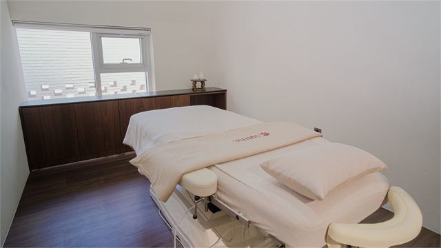 Treatment room with a treatment bed at Sartine Skin Clinic