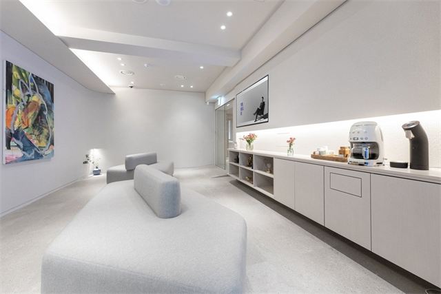 Waiting lounge with sofas and a refreshment counter at Will Be Plastic Surgery