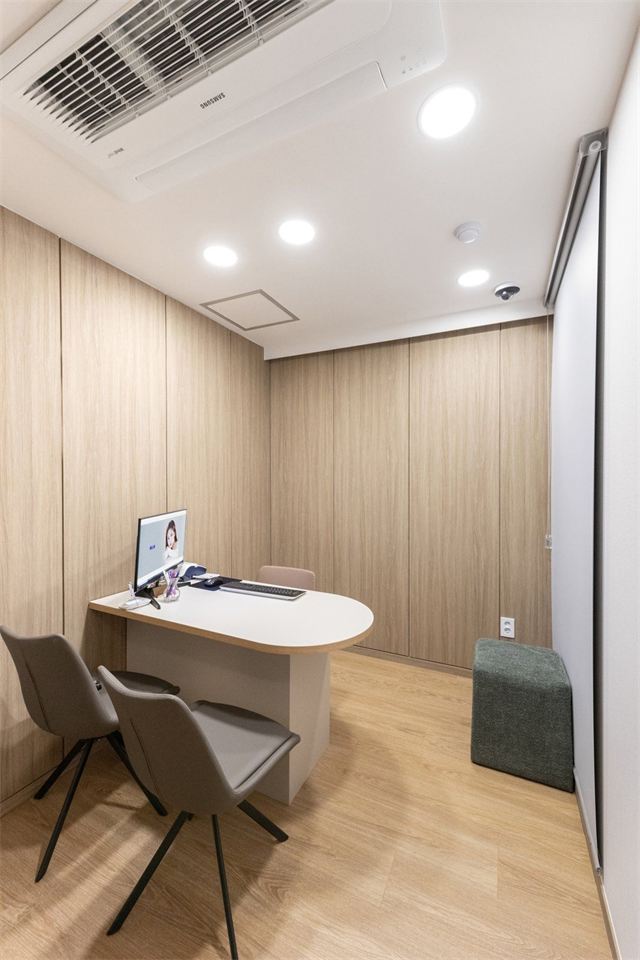 Consultation room with a desk, monitor and two chairs at Will Be Plastic Surgery