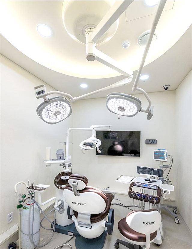 Second-floor surgery room with operating lights and a dental chair at Yonsei Heal Dental Hospital